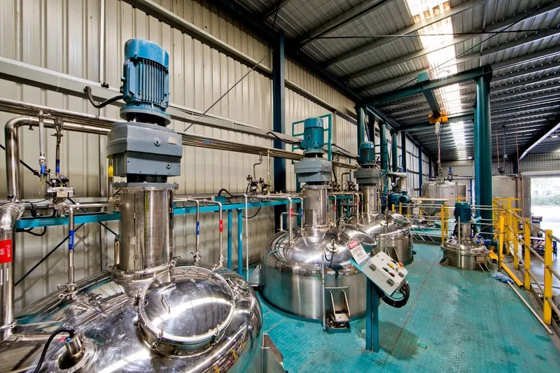 Stainless process vessels and pipework in a chemical production hall