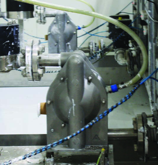 Close view of an installed diaphragm pump and connected utility lines